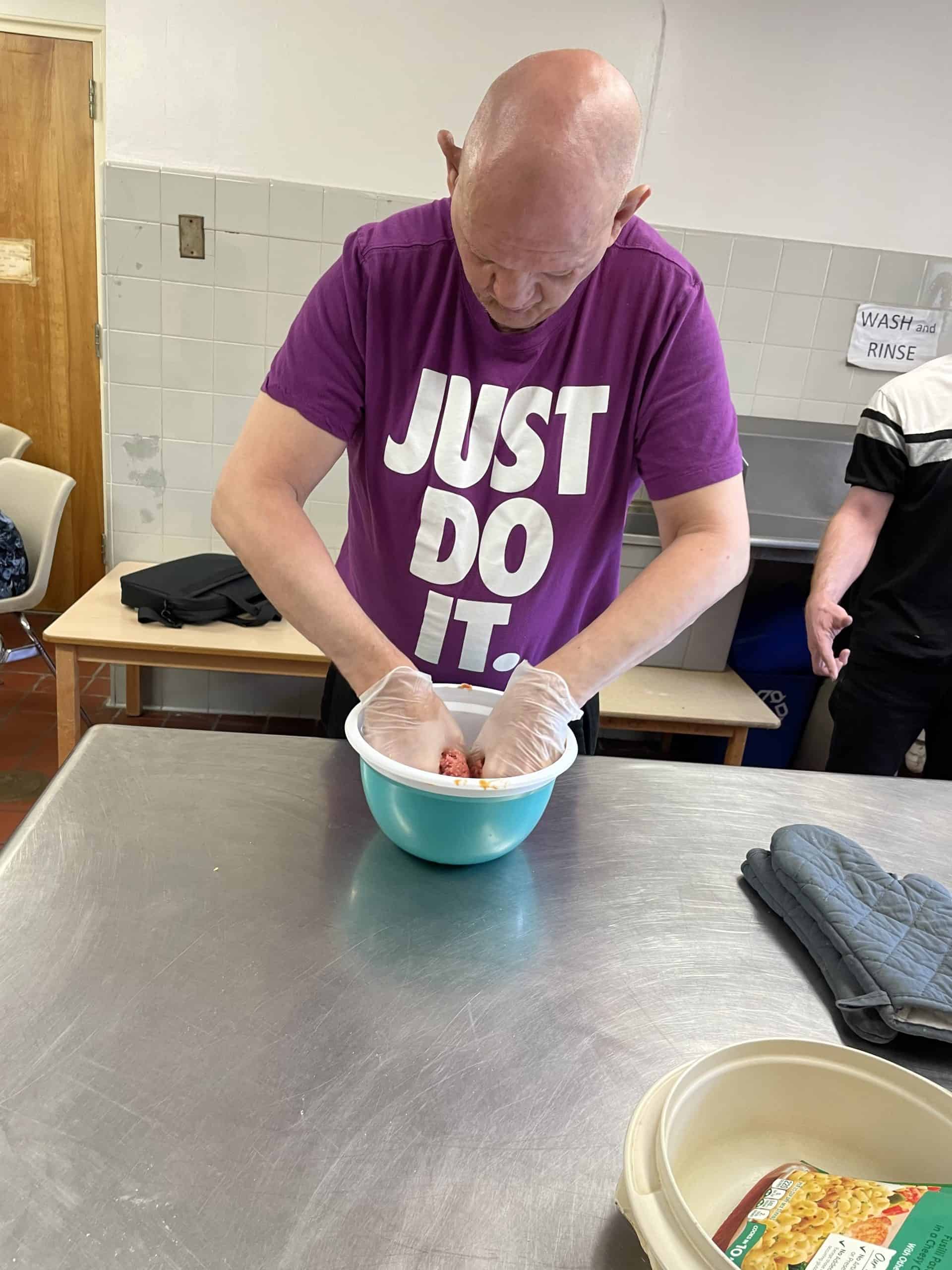 Man mixing dough in a bowl.