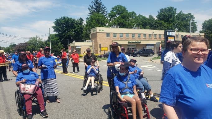 New Concepts for Living residents in wheelchairs and staff marching in the Rochelle Park Memorial Day parade.