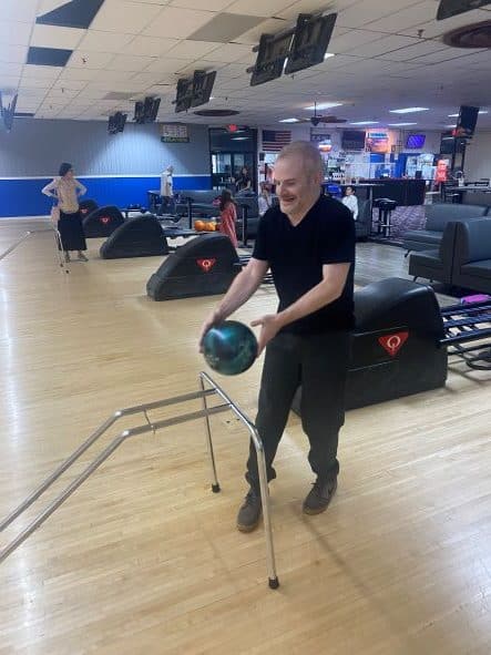 Man bowling with a green ball.